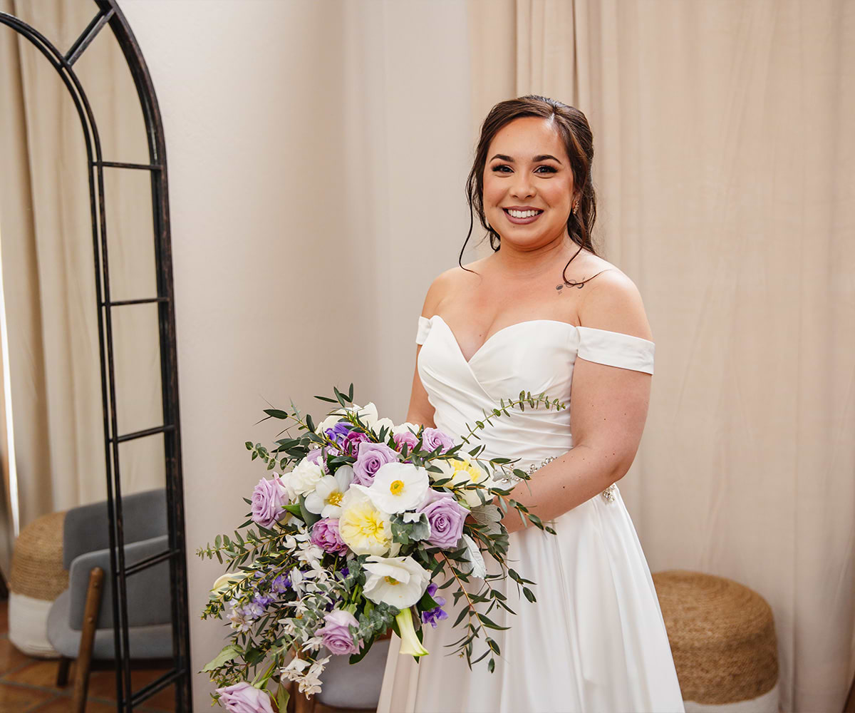 Bride with bouquet smiling in get ready room - Carmel Fields by Wedgewood Weddings