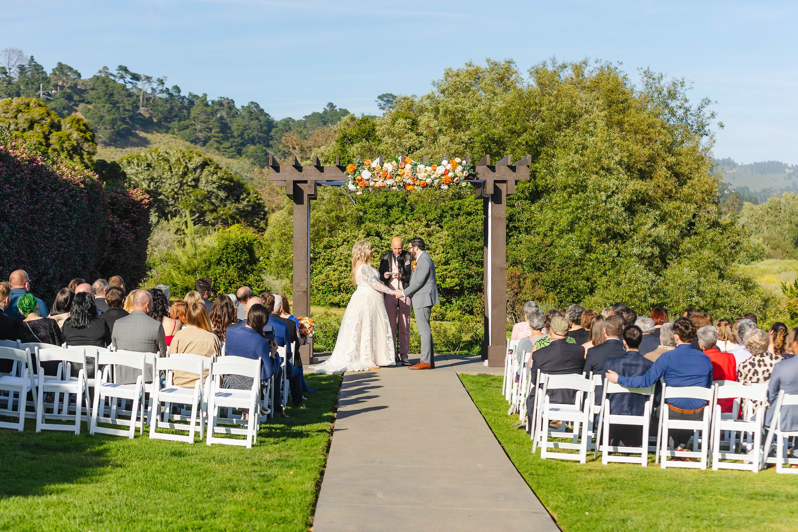 Couple holding hands during the ceremony - Carmel Fields by Wedgewood Weddings