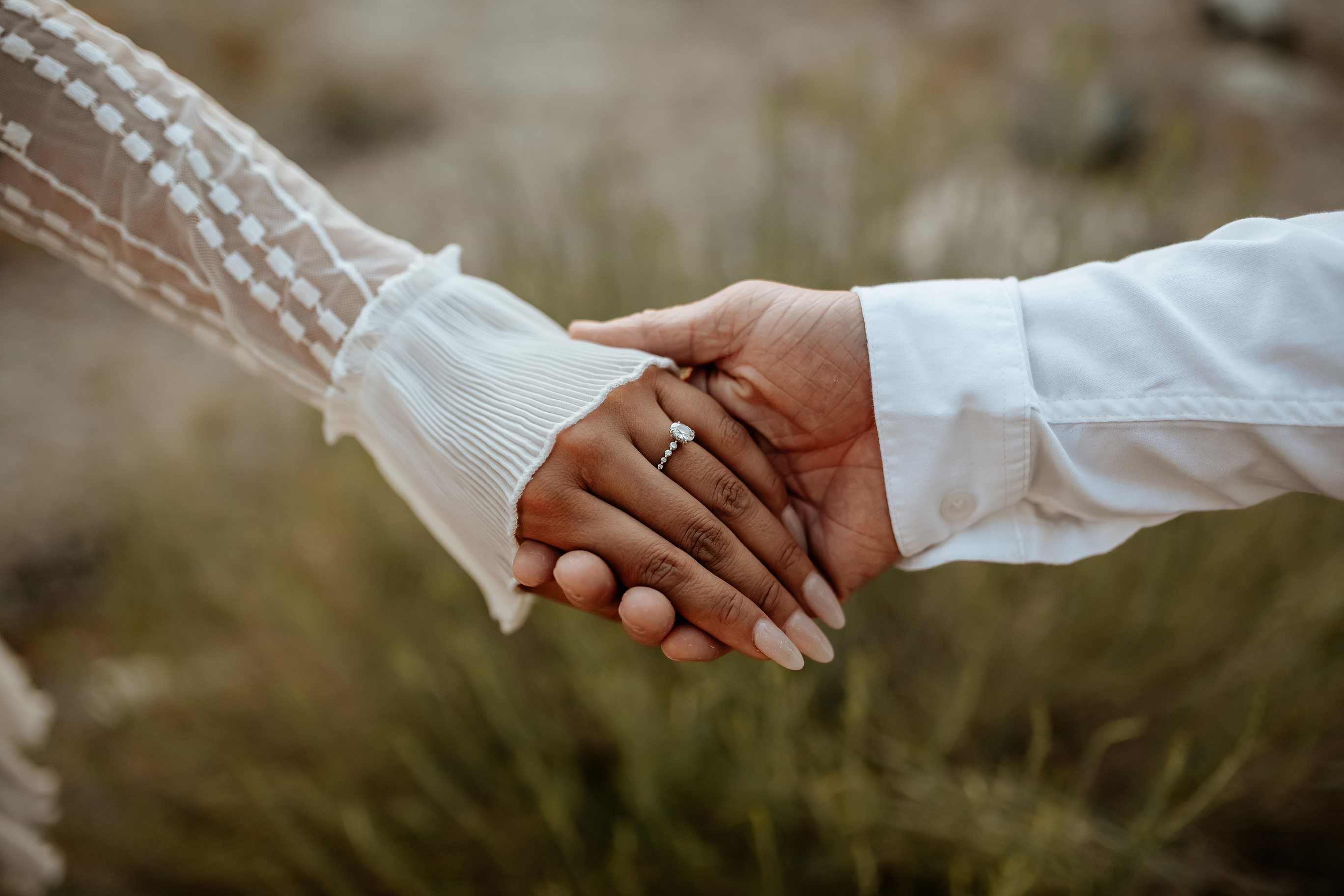 Couple holding hands, closeup of ring