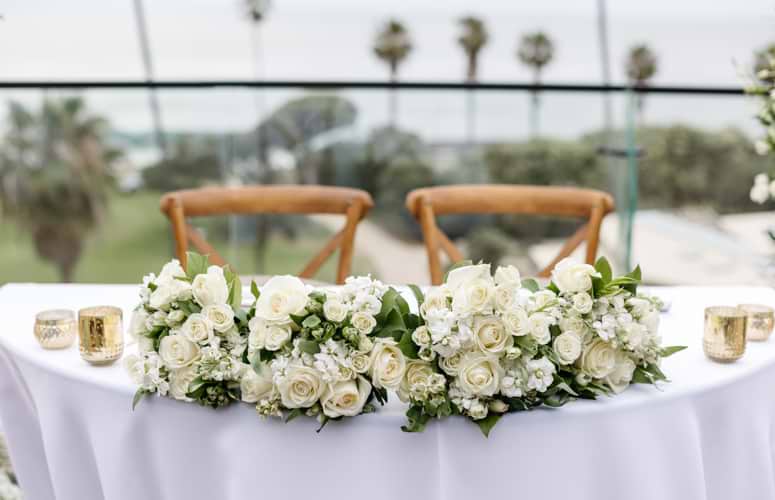 Sweetheart table with delicate white florals and gold accents - La Jolla Cove Rooftop by Wedgewood Weddings - 1