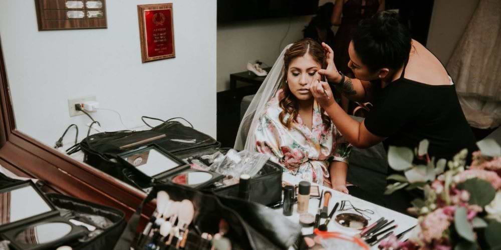 bride and makeup artist applying makeup