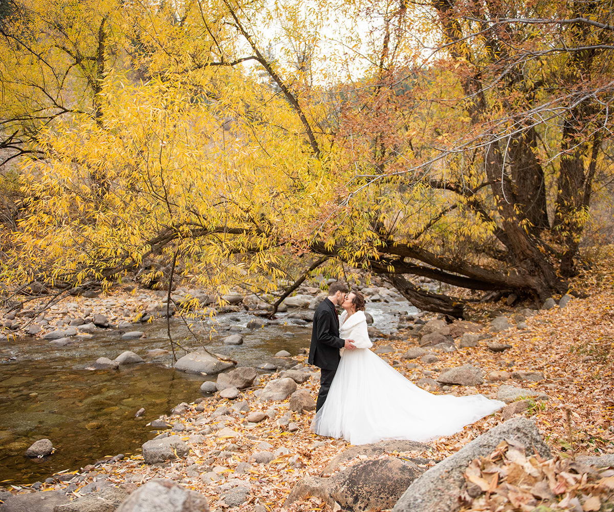 Couple kissing by creek in fall -Boulder Creek by Wedgewood Weddings