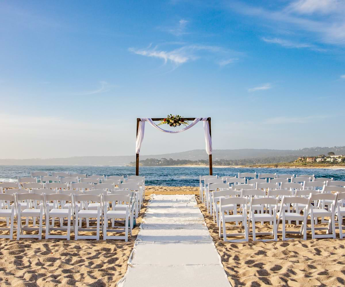 Beach ceremony with dark wood arbor and white aisle runner - Carmel Fields by Wedgewood Weddings