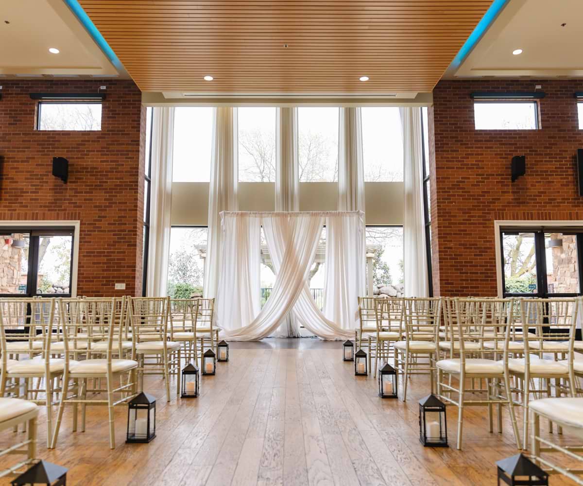 Indoor ceremony site with aisle lanterns - Evergreen Springs by Wedgewood Weddings