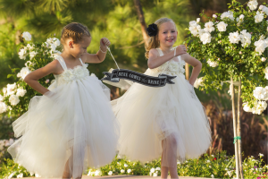 flower girls holding here comes the bride sign