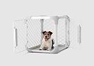 A dog sitting inside of a white dog crate