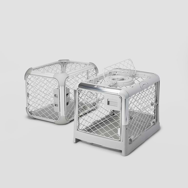  A Revol and an Evolv dog crate sitting next to each other 