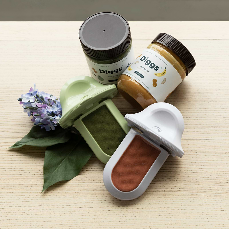 a wooden table topped with jars of treat spreads and two groovs