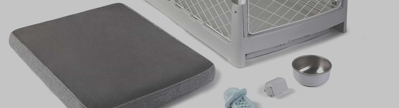  A dog crate, bed, bowl, and training aid on a white background 