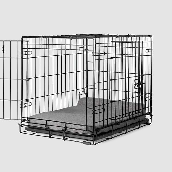  A dog crate with a Bolstr bed inside of it 