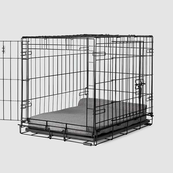 A dog crate with a Bolstr bed inside of it