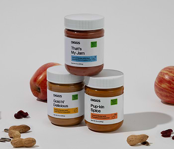  All three flavors of Diggs Treat Spreads on a white background with apples, cranberries, and pumpkin seeds 