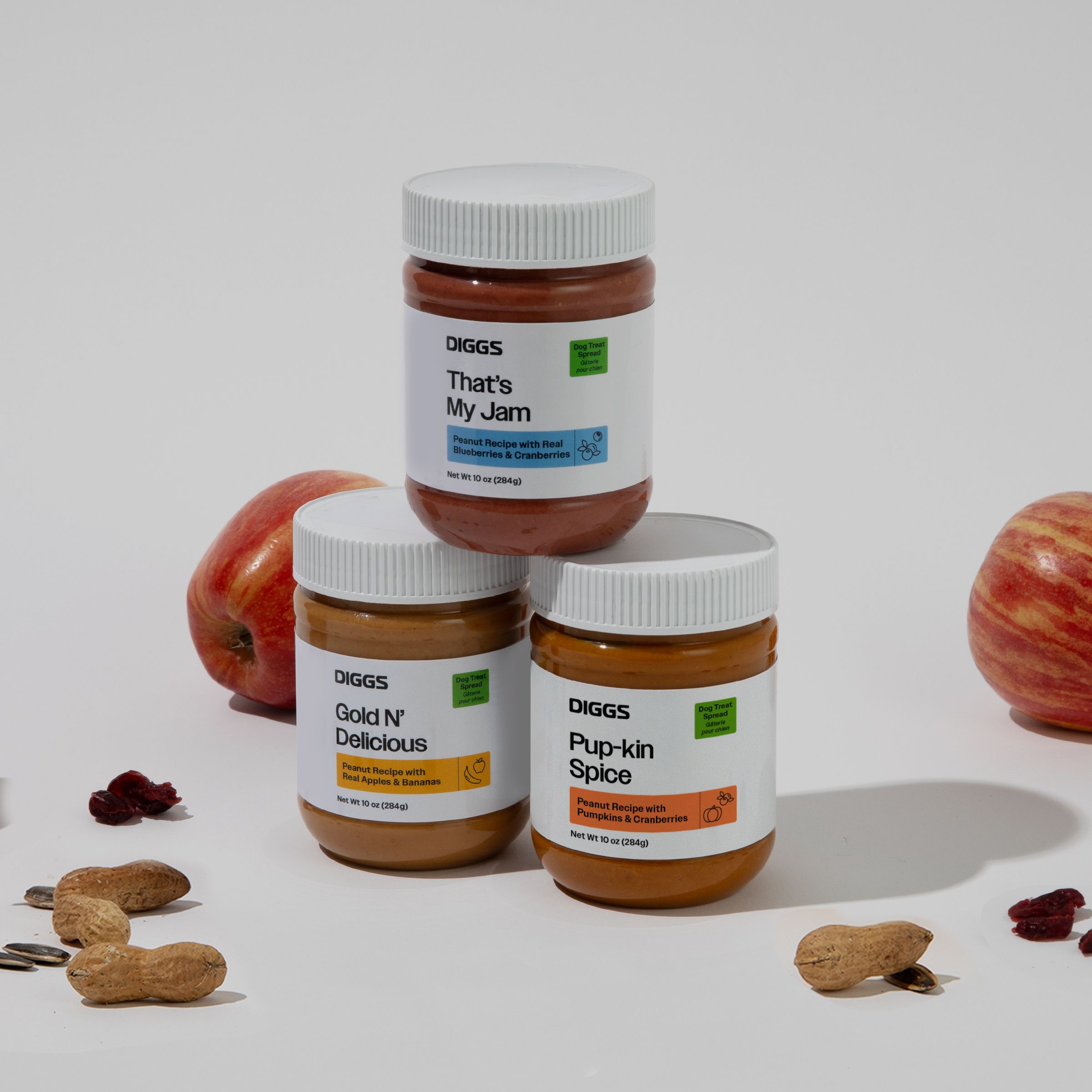 All three flavors of Diggs Treat Spreads on a white background with apples, cranberries, and pumpkin seeds
