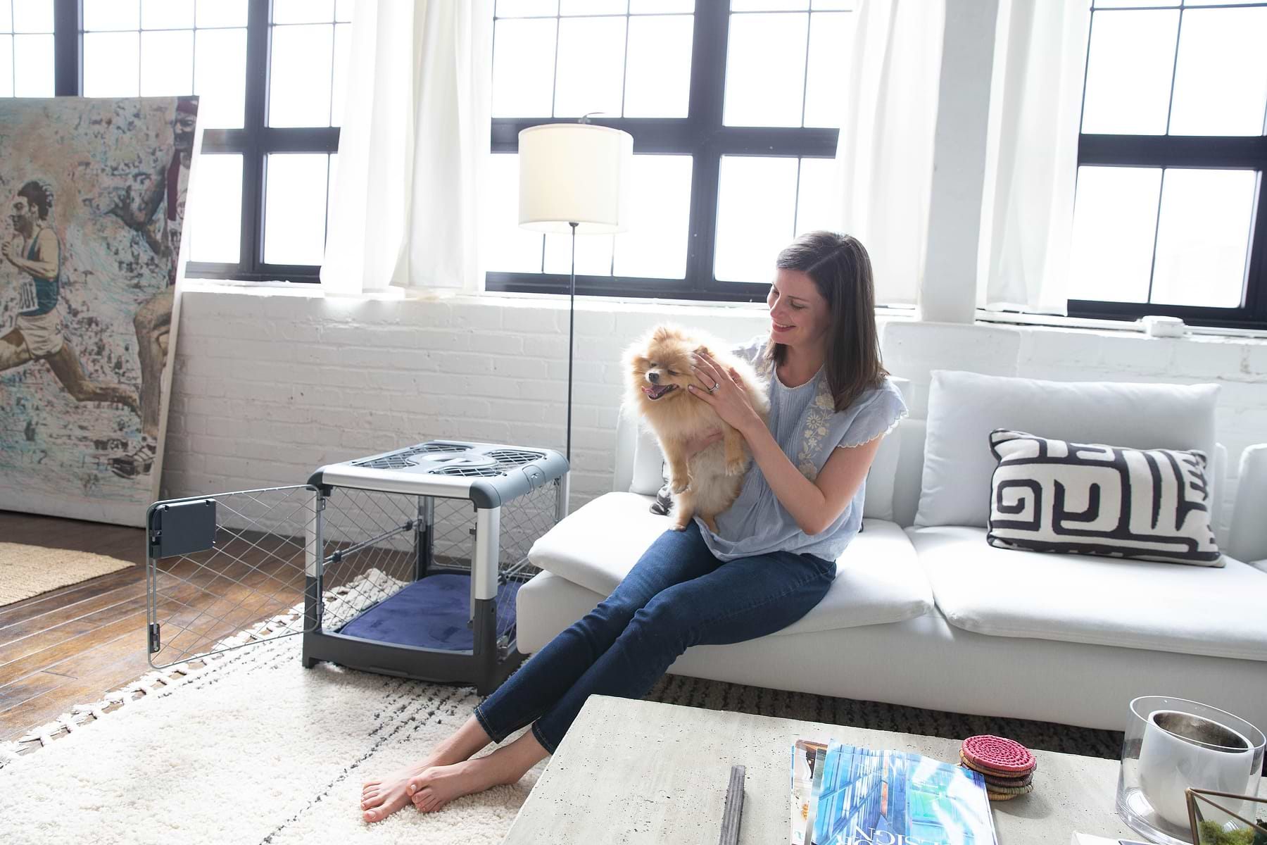  a woman sitting on a couch holding a dog next to a Grey Revol 