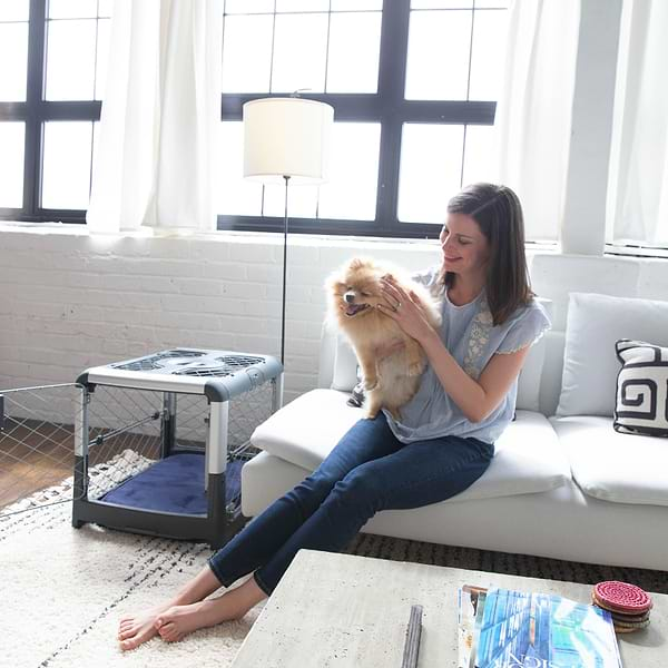  a woman sitting on a couch holding a dog next to a Grey Revol 