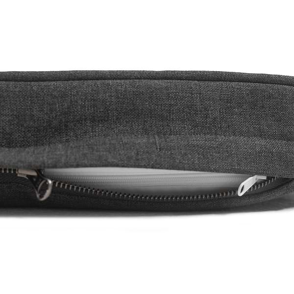 A Diggs snooz pad in dark Grey color with the zipper a bit opened, showing the white inner liner and white zipper of the snooz pad. 