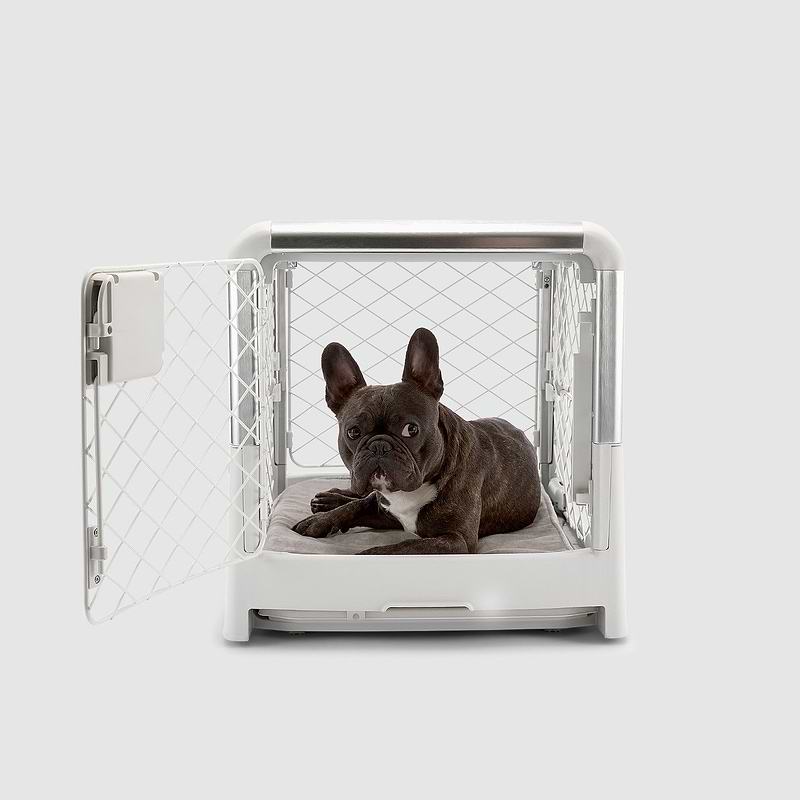 A dog laying in a small white dog crate