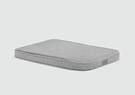 A gray mattress with no sheets on it