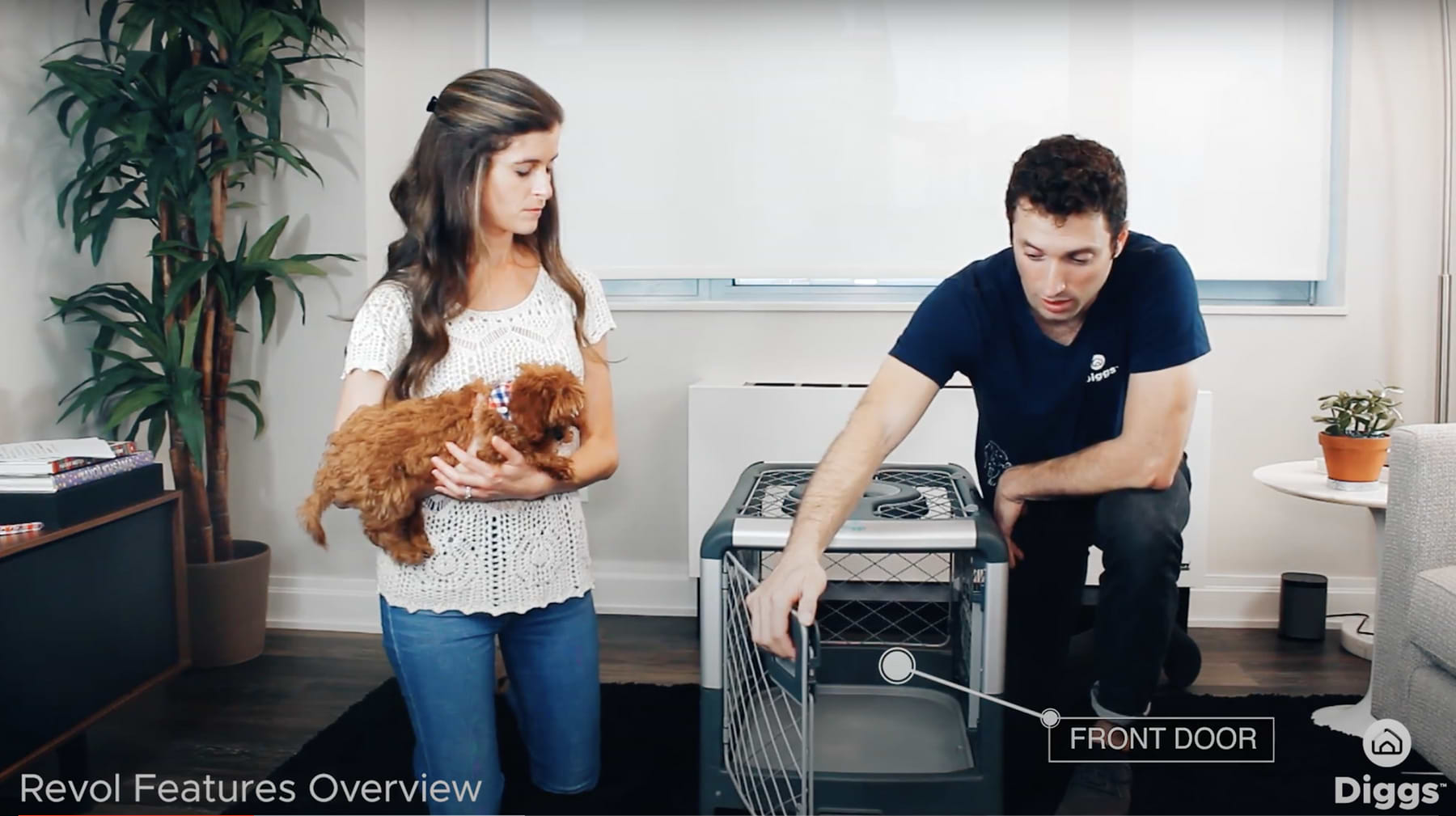 Screen Shot 2020 08 05 at 7 a woman holding a dog next to a man in front of a grey Revol crate