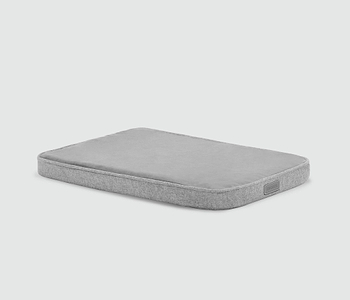  A gray mattress with no sheets on it 
