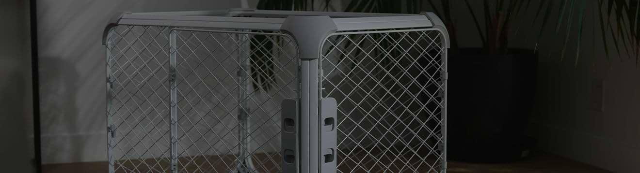 PLP Banners Evolv Desktop Darken A large Evolv dog crate sitting next to a potted plant