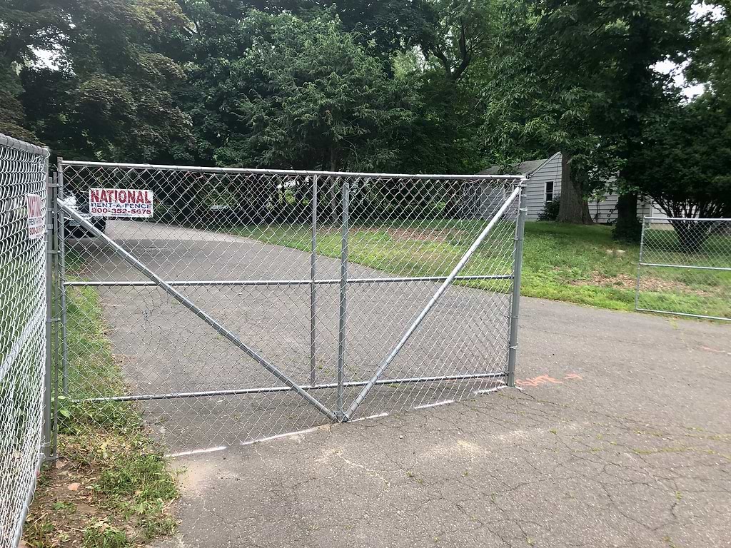 Chain-link fencing has been erected on Hiawatha Lane Extension, walling off the houses that are to be demolished for a 157-unit development. / Photo by Thane Grauel.