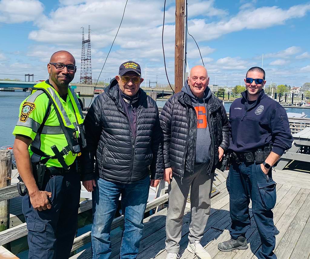 Norwalk Police Marine Unit Officer Owen Lee, left, Sgt. Justin Bisceglie, right, and the two men rescued from a windblown-sailboat off Compo Beach on Wednesday. Norwalk Police Department photo.