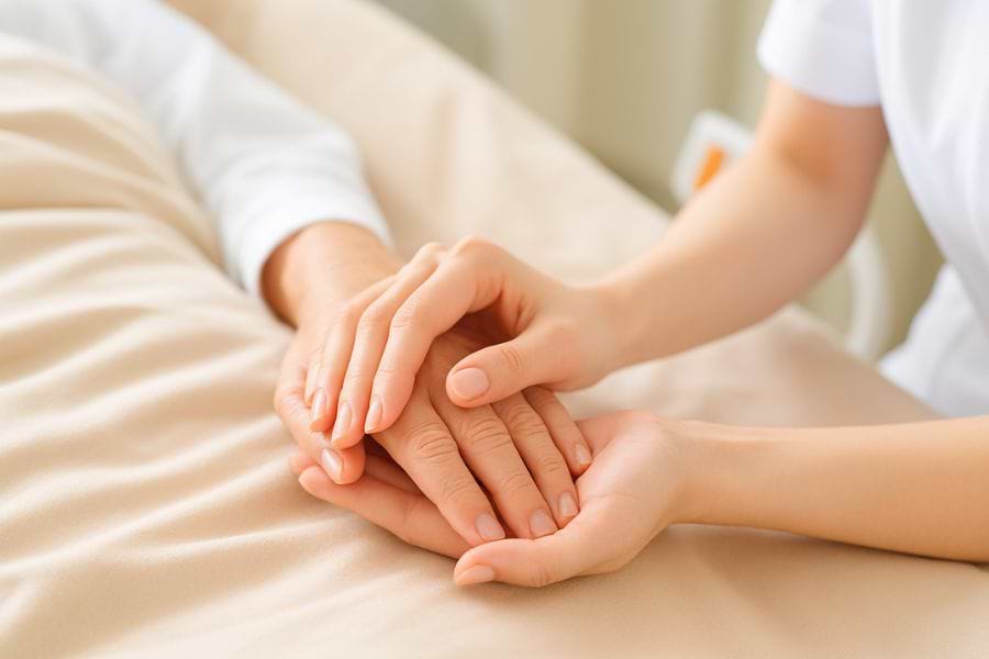 患者の手を握る看護師