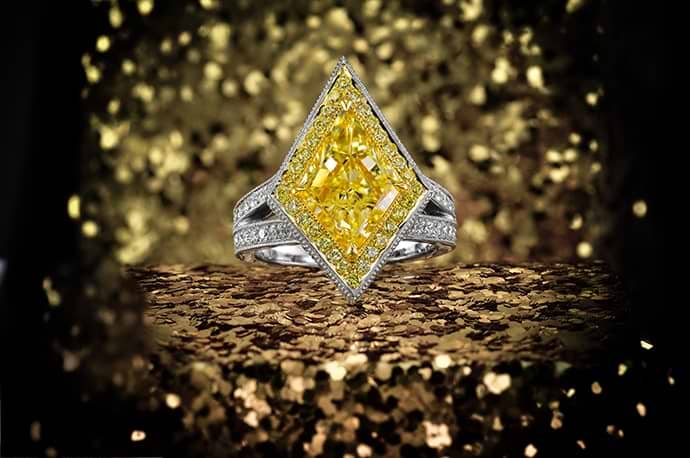 A 3.97 carat yellow diamond kite, halo ring