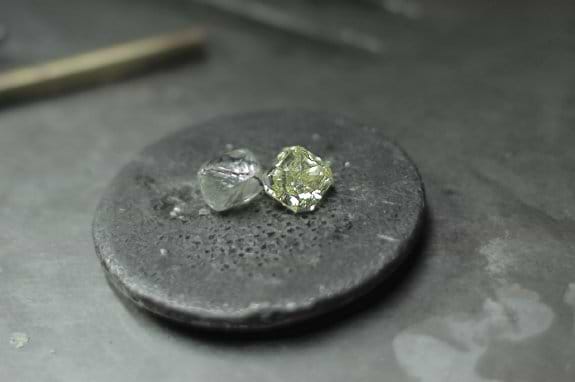 A rough diamond next to a polished diamond