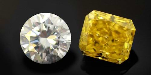 A natural yellow diamond next to a colorless diamond