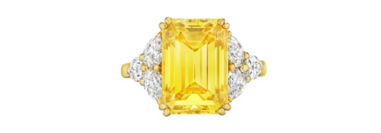 This emerald-cut, 6.09-carat, fancy-vivid-yellow, VVS1-clarity diamond ring with white diamond accents by designer Cauet 
