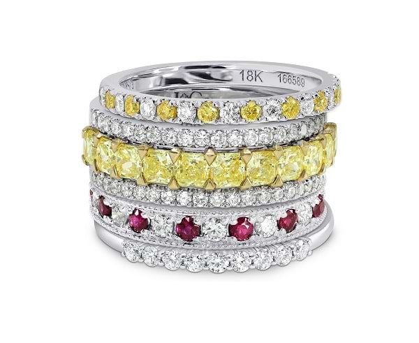 A stack of diamond, yellow diamond, and gemstone wedding bands