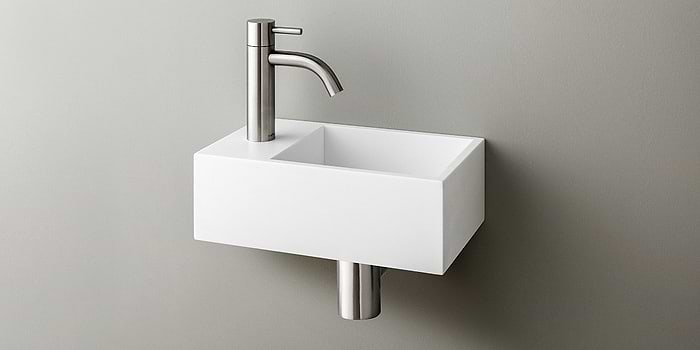 Solid Surface Corian toiletfontein, wasbak of wastafeltje voor op het toilet. Dit mat witte Corian toiltfonteintje kan met kraangat of zonder kraangat geleverd worden. De wasbak uitsparing zit rechts. Het Basics toiletfontein Rechts 300 heeft een lengte van 30 cm, diepte van 18 cm en hoogte van 10 cm.