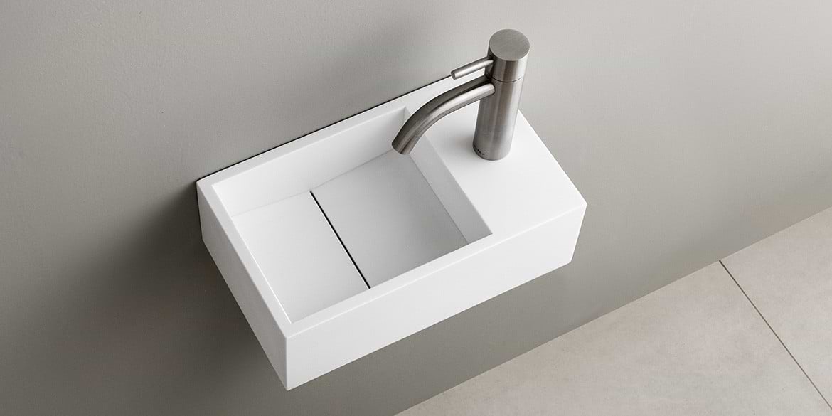 Solid Surface Corian toiletfontein, wasbak of wastafeltje voor op het toilet. Dit mat witte Corian toiltfonteintje kan met kraangat of zonder kraangat geleverd worden. De wasbak uitsparing zit links. Het Basics toiletfontein Links 300 heeft een lengte van 30 cm, diepte van 18 cm en hoogte van 10 cm.