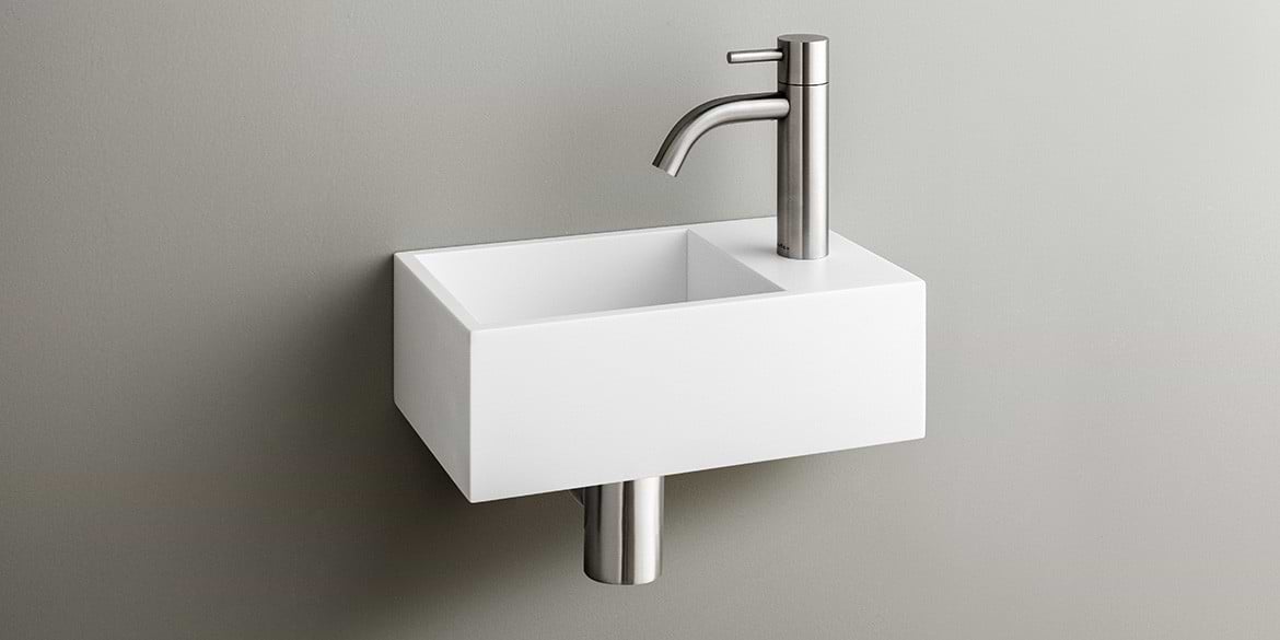 Solid Surface Corian toiletfontein, wasbak of wastafeltje voor op het toilet. Dit mat witte Corian toiltfonteintje kan met kraangat of zonder kraangat geleverd worden. De wasbak uitsparing zit links. Het Basics toiletfontein Links 300 heeft een lengte van 30 cm, diepte van 18 cm en hoogte van 10 cm.