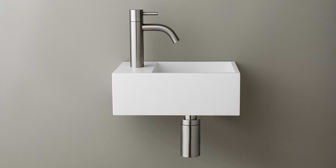 Solid Surface Corian toiletfontein, wasbak of wastafeltje voor op het toilet. Dit mat witte Corian toiltfonteintje kan met kraangat of zonder kraangat geleverd worden. De wasbak uitsparing zit rechts. Het Basics toiletfontein Rechts 300 heeft een lengte van 30 cm, diepte van 18 cm en hoogte van 10 cm.