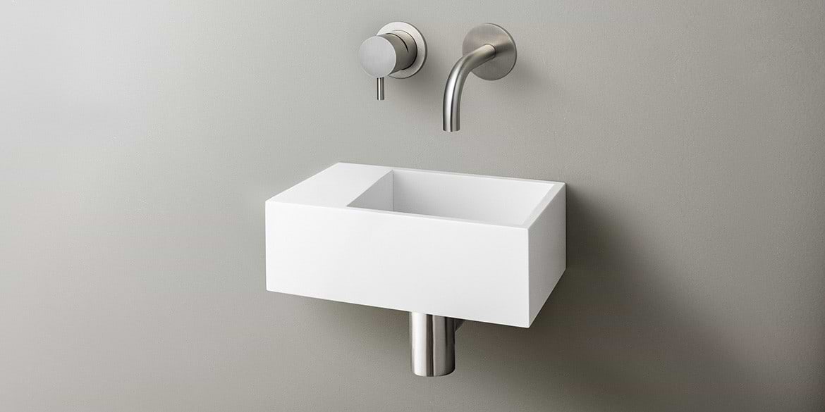 Solid Surface Corian toiletfontein, wasbak of wastafeltje voor op het toilet. Dit mat witte Corian toiltfonteintje kan met kraangat of zonder kraangat geleverd worden. De wasbak uitsparing zit rechts. Het Basics toiletfontein Rechts 300 heeft een lengte van 30 cm, diepte van 18 cm en hoogte van 10 cm.