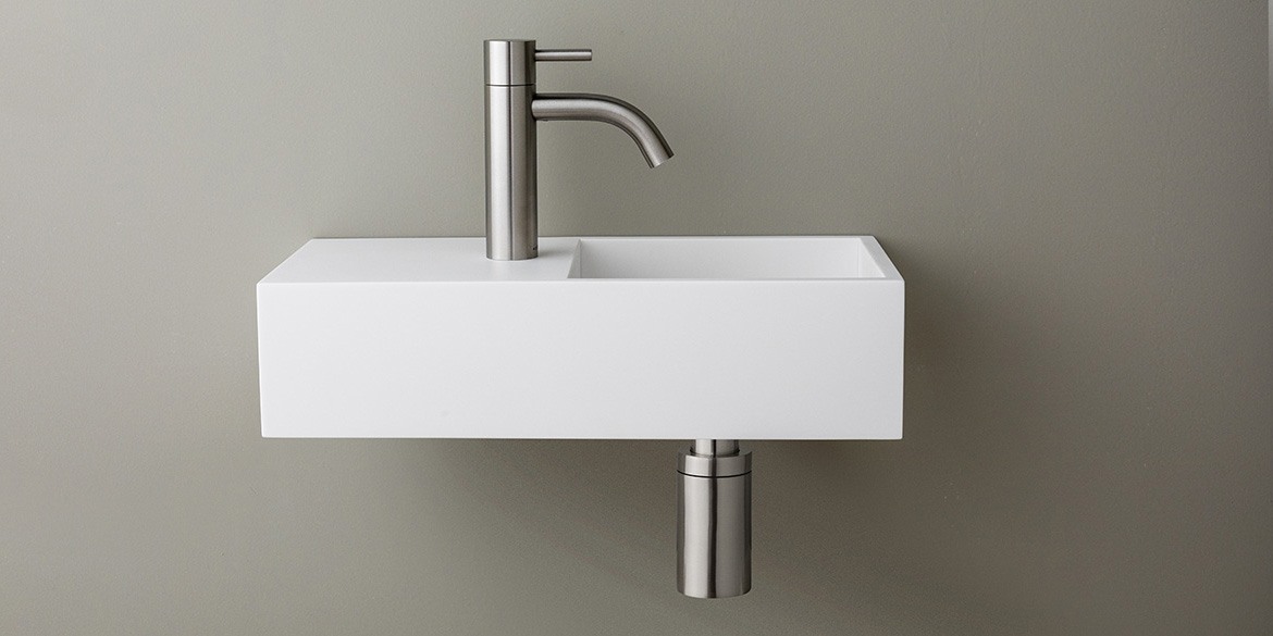Solid Surface Corian toiletfontein, wasbak of wastafeltje voor op het toilet. Dit mat witte Corian toiltfonteintje kan met kraangat of zonder kraangat geleverd worden. De wasbak uitsparing zit rechts. Het Basics toiletfontein Rechts 400 heeft een lengte van 40 cm, diepte van 18 cm en hoogte van 10 cm.