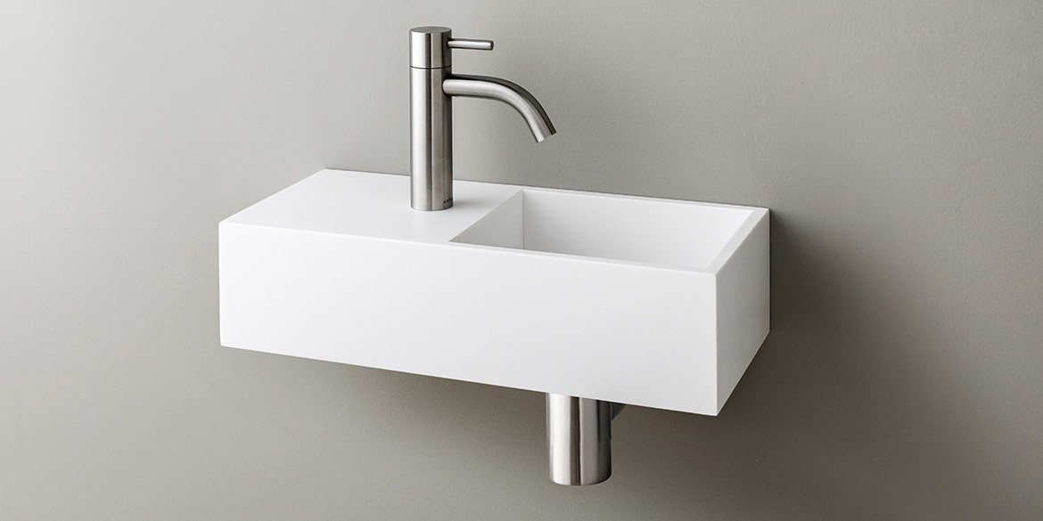 Solid Surface Corian toiletfontein, wasbak of wastafeltje voor op het toilet. Dit mat witte Corian toiltfonteintje kan met kraangat of zonder kraangat geleverd worden. De wasbak uitsparing zit rechts. Het Basics toiletfontein Rechts 400 heeft een lengte van 40 cm, diepte van 18 cm en hoogte van 10 cm.
