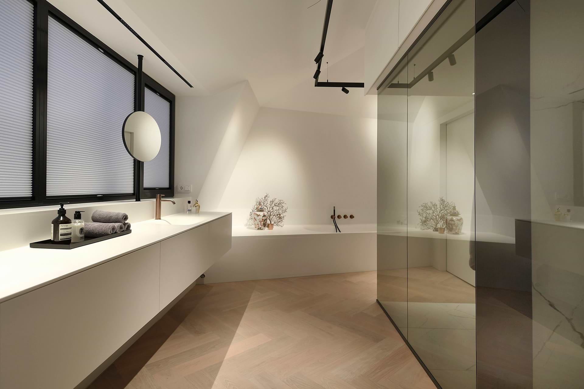 Moderne badkamer met wit Corian wastafelmeubel, zwarte accenten en geïntegreerd ligbad