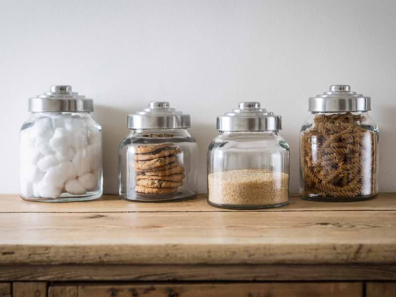 Collection of Glass Jars filled with cotton wool, cookies, brown sugar and fussili pasta