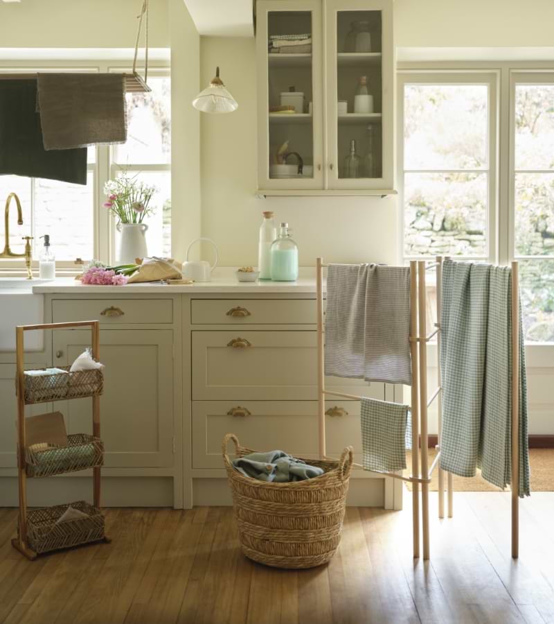 A white utility room with a clothes horse and sink.