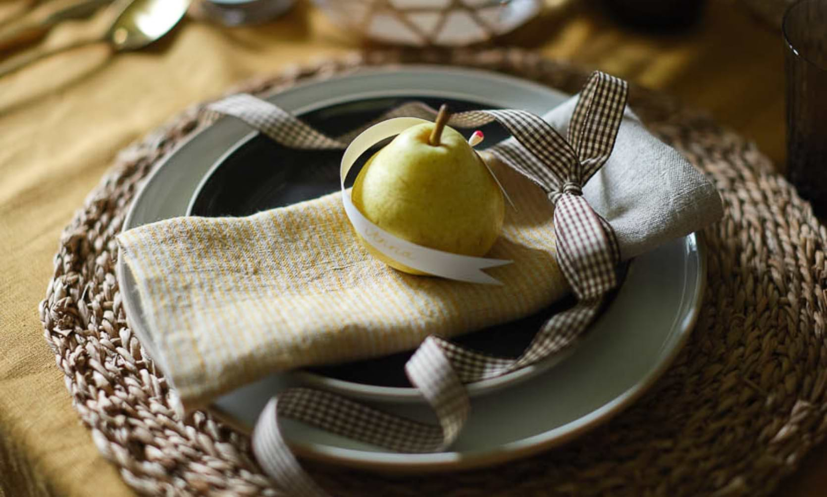 Pear sitting on Hazleton Napkin, Holwell Side Plate in Tarn Blue and Holwell Dinner Plate in White