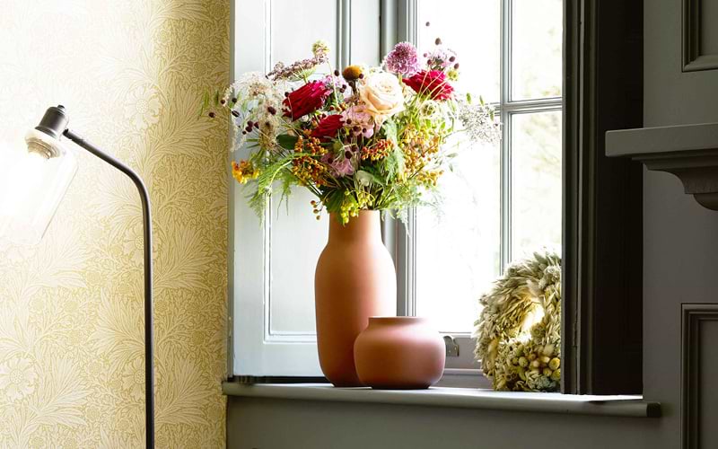 Flowers on display in a vase by the window