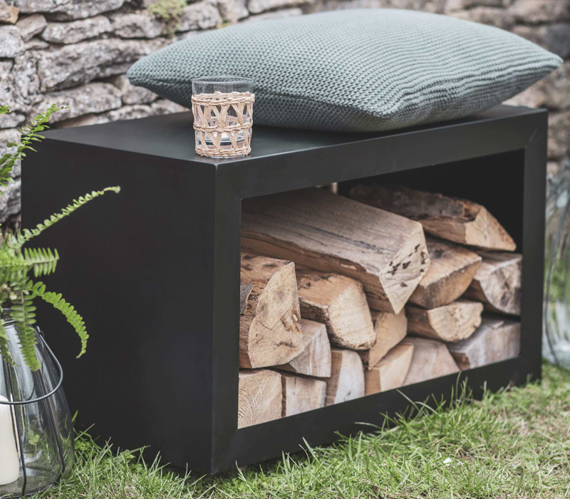 Black Bench that doubles as a Log Holder in the garden