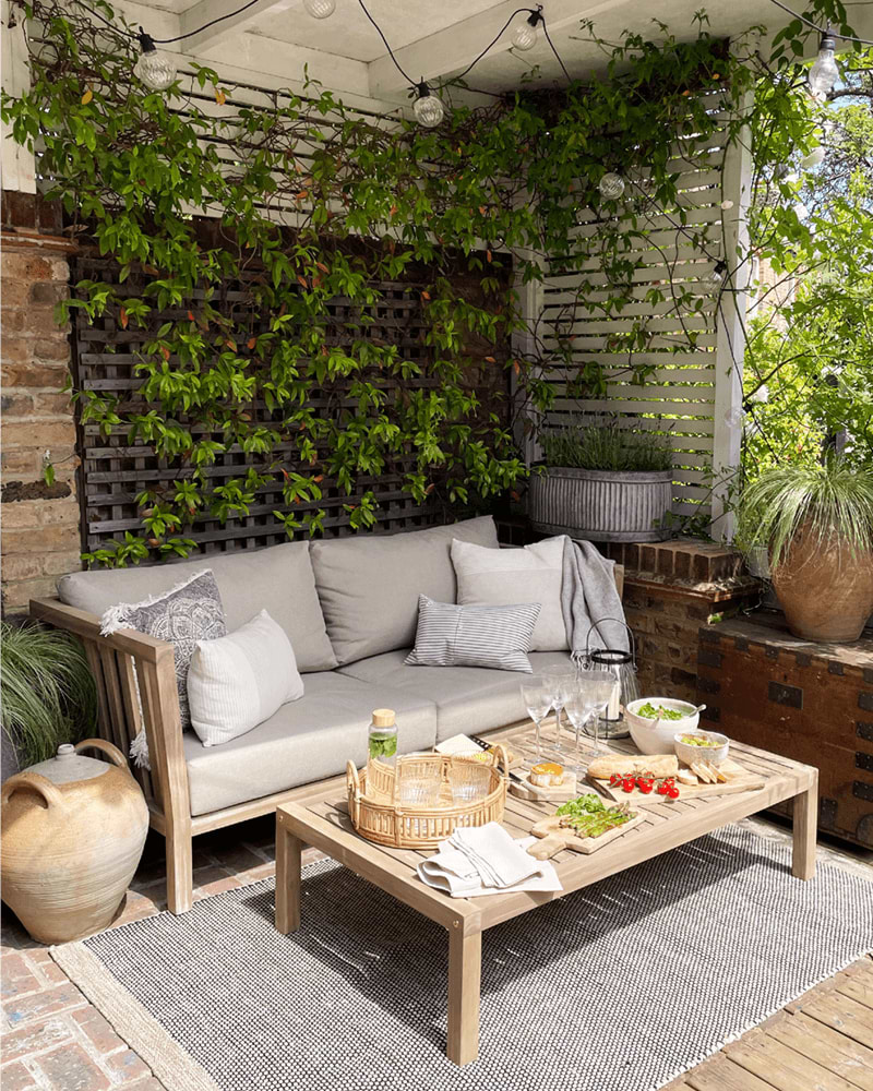 Garden sun trap corner with sofa and picnic set up