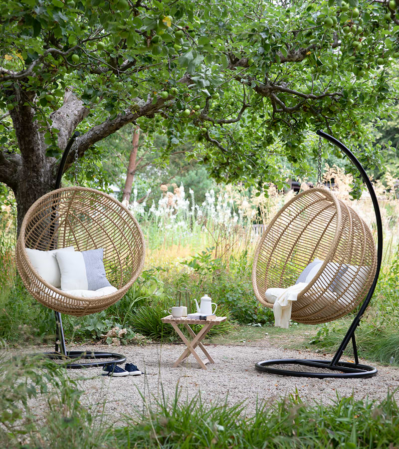Pair of Hampstead Hanging Nest Chairs surrounded by greenery