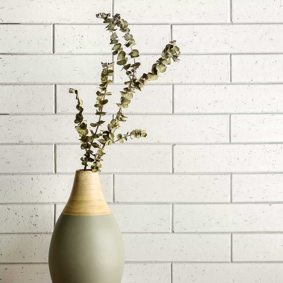 white clay subway tile used on wall with branch in a vase 