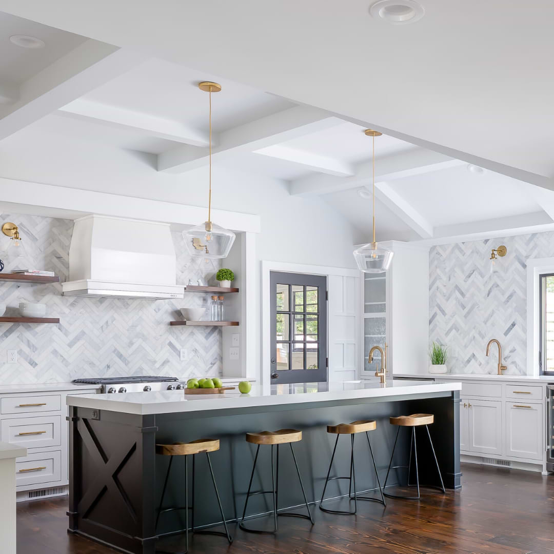 Brushed Stone Asian Statuary 2x8 Marble Subway Tile shown on the kitchen wall above the counter tops in a herringbone pattern